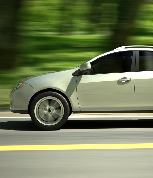 Car with tinted windows driving down the street