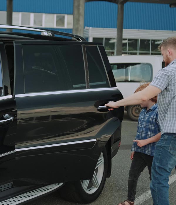 Father opening door to SUV with tinted windows