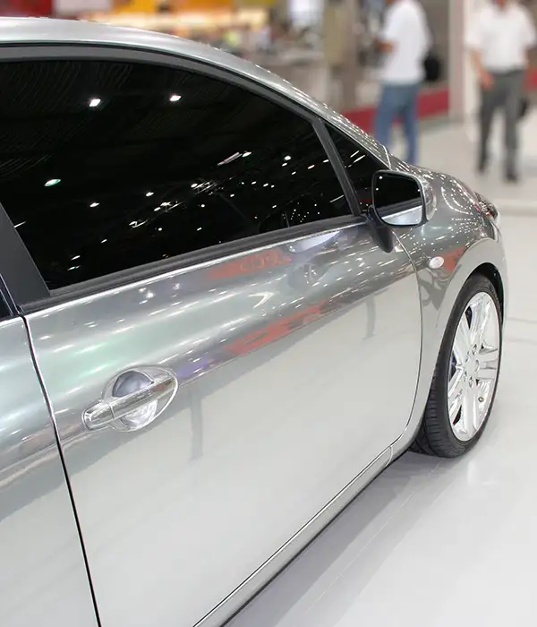 silver car with dark tinted windows under bright lights in a showroom